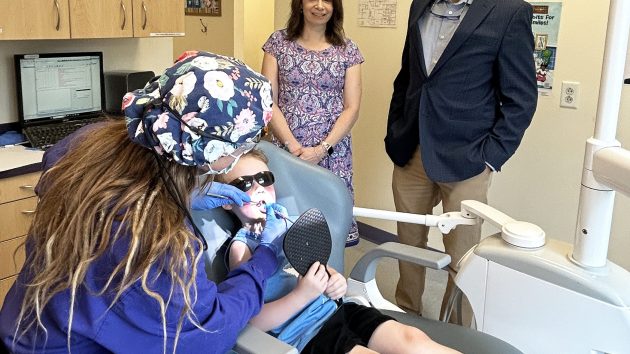 Photo caption: Dental hygienist Julia Nield counts Jasper Donahue's teeth as State Senator Paul Honig and Brooker Memorial Executive Director Christina Emery look on during a tour of the pediatric dental center July 2. Photo courtesy of Brooker Memorial